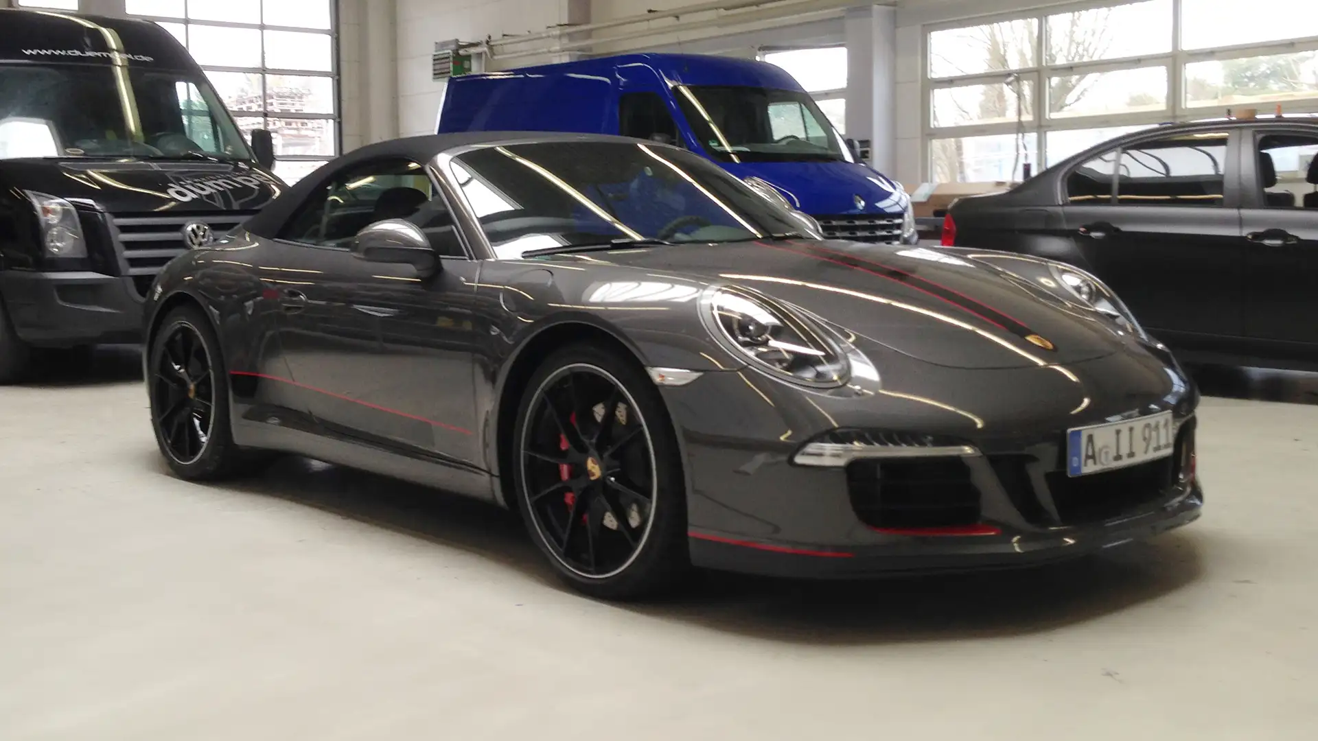 Werbetechnik Dümpel - Augsburg | Grauer Porsche 911 Cabrio Sportwagen - Parkhaus - schwarzer Van - blauer Van - graue Limousine - Luxusfahrzeuge.
