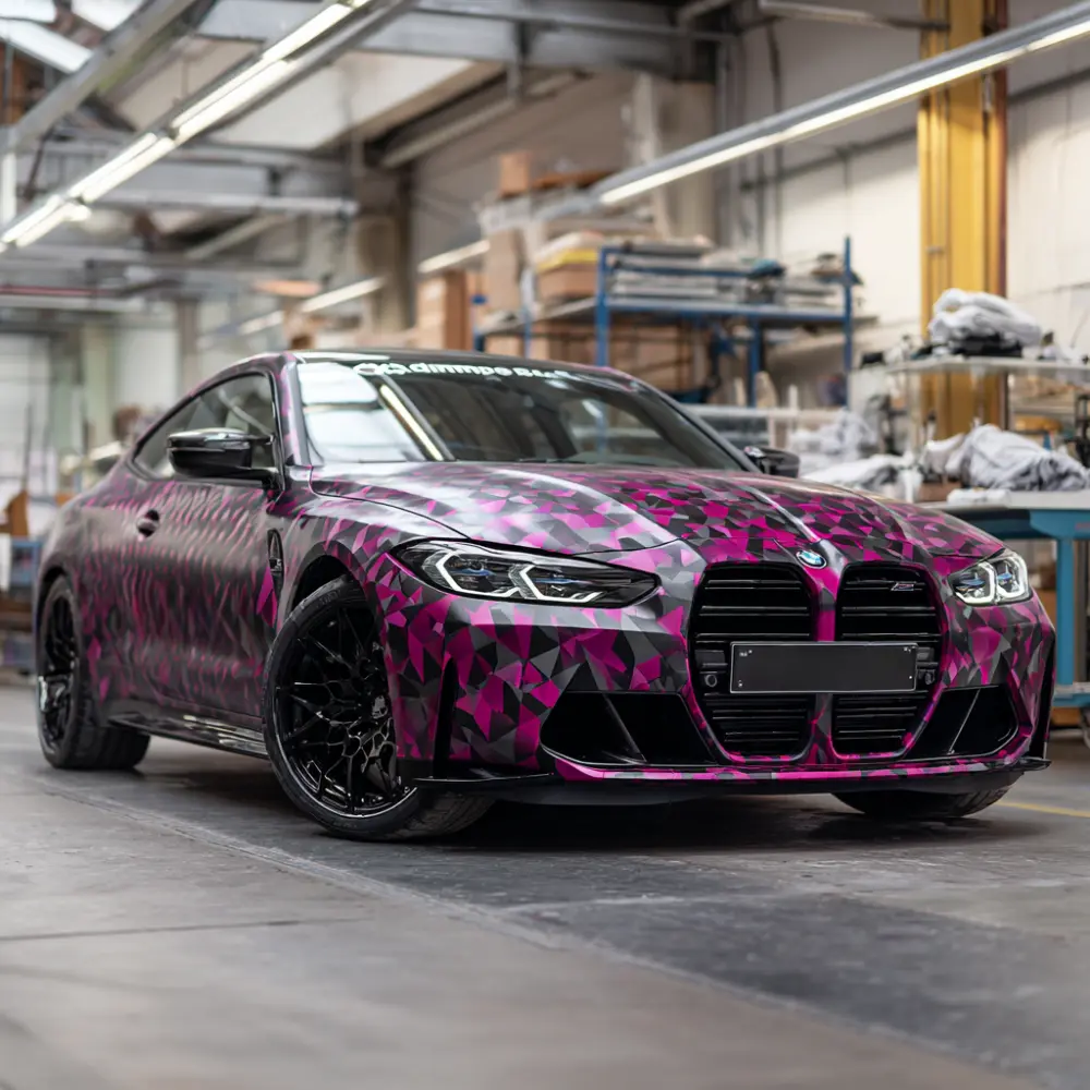Werbetechnik Dümpel - Augsburg | Schwarzer Sportwagen - geometrische rosa lila camo wrap - in der industriellen Werkstatt geparkt - Luxus-Fahrzeug Anpassung Garage.