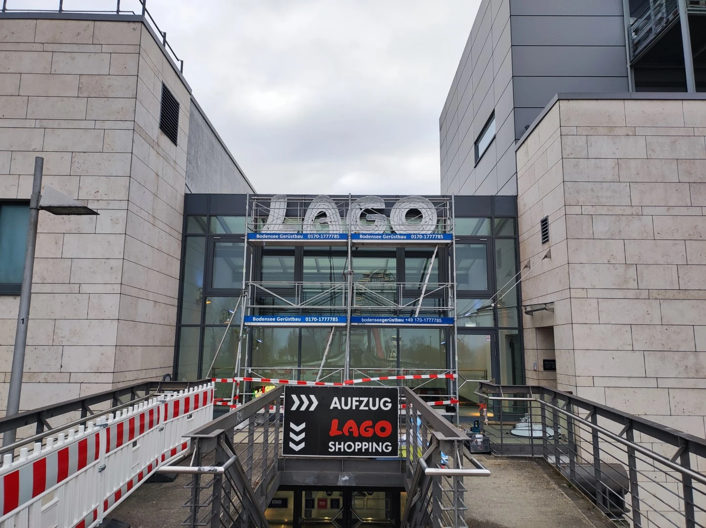 Werbetechnik Dümpel - Augsburg | LAGO-Einkaufszentrum-Eingang-mit-Gerüst-Aufzug-gerichtetes-Zeichen-Einzelhandel-Barrierefreiheit-kleine-Navigation.