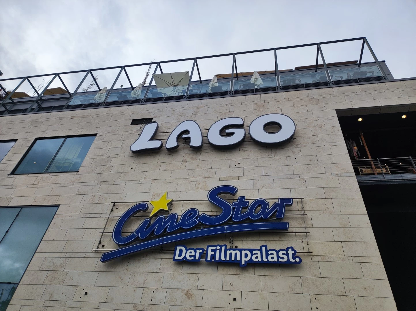 Werbetechnik Dümpel - Augsburg | LAGO Einkaufszentrum - CineStar Der Filmpalast Kino - Steinfassade Gebäude außen - low angle photo - Stadtarchitektur.