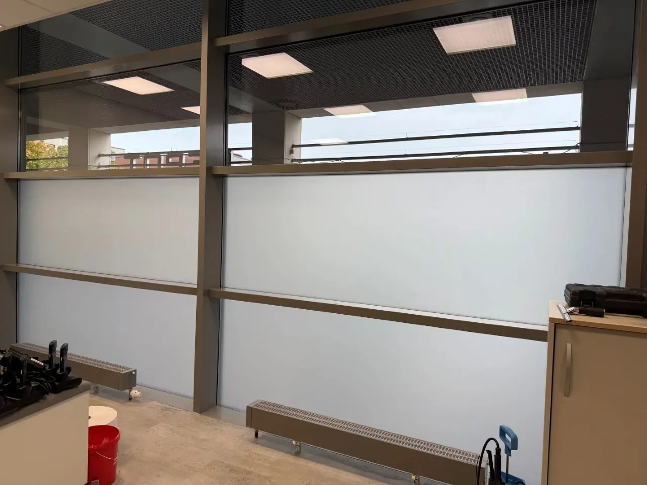 Werbetechnik Dümpel - Augsburg | Modernes Bürodesign - Milchglasfenster - Metallrahmen - Leuchtstoffröhrenbeleuchtung - minimalistische Möbel - zeitgenössischer Arbeitsplatz.